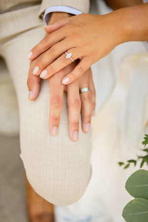 Close-up shots of wedding rings and hands against light textured background.