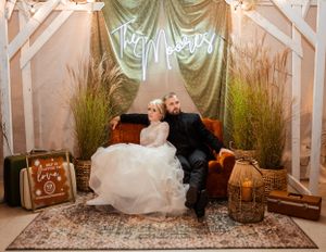 Vintage-inspired wedding photo booth setup with antique furniture and soft lighting.