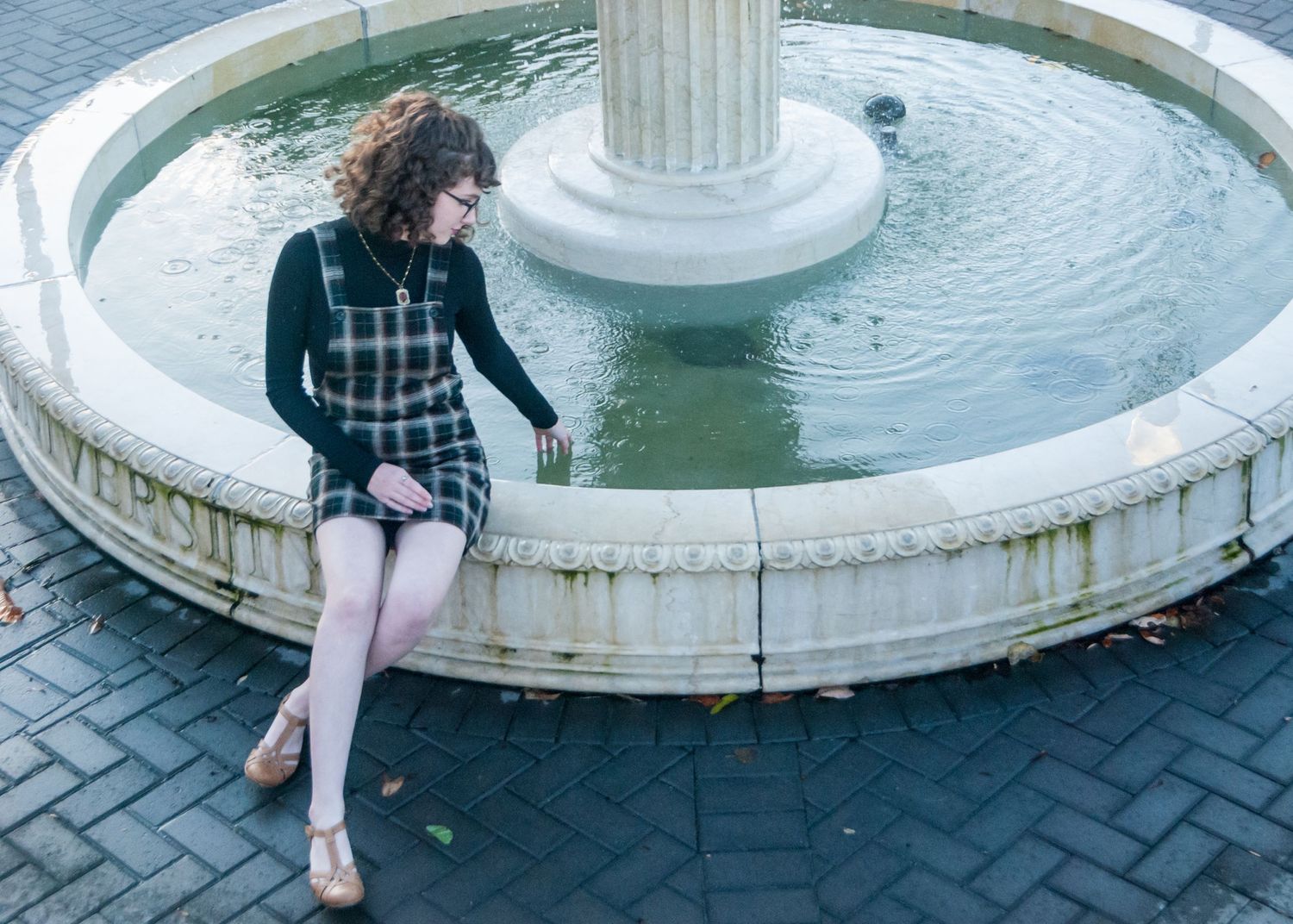 Woman running her fingers through the water in a fountain at Western Kentucky University in Bowling Green, Kentucky