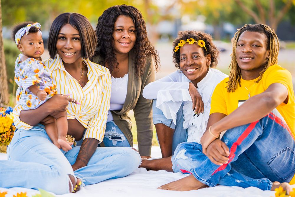 Cheerful family group photo session outdoors with bright yellow background.