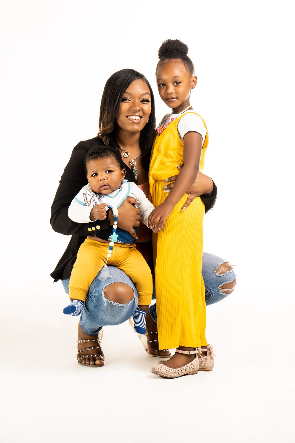 Studio family portrait series with coordinated yellow and denim outfits against white background.