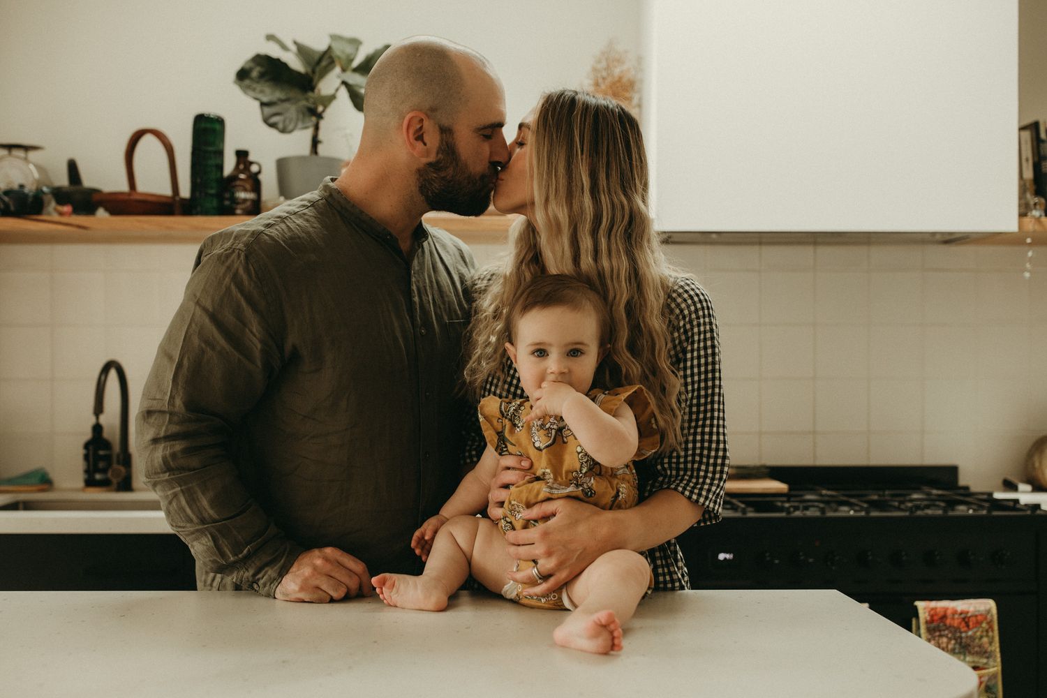 An intimate family moment shared in a bright modern kitchen.
