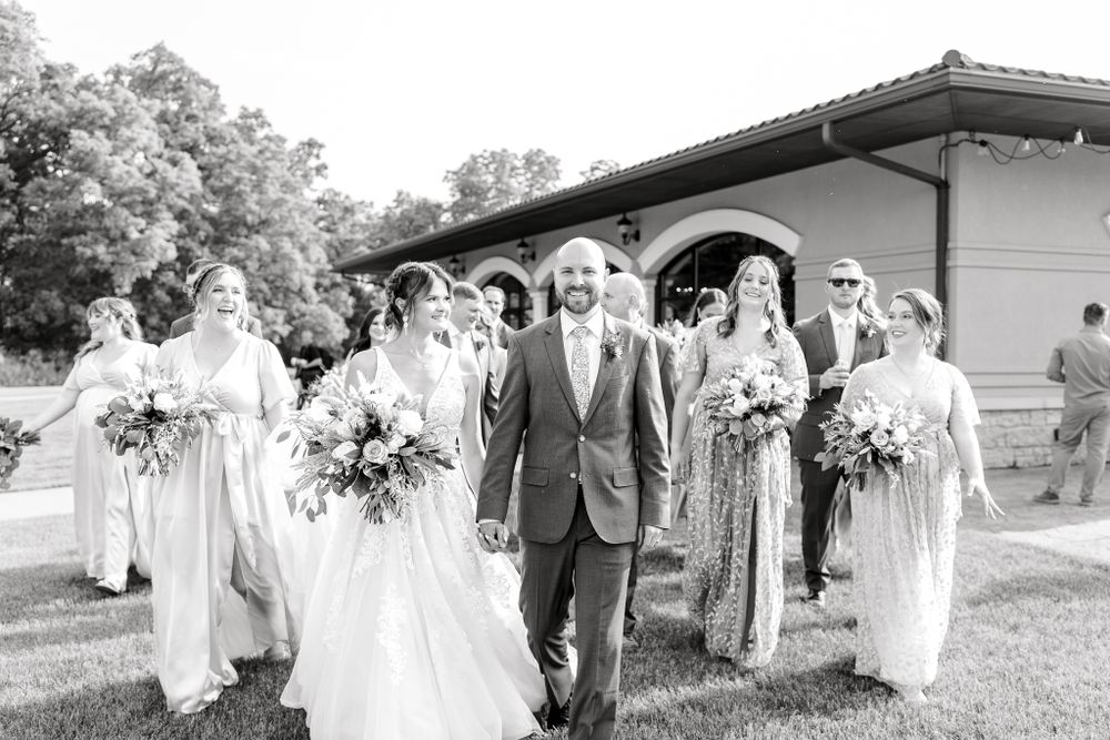 Black and white photo of wedding party walking together outdoors.