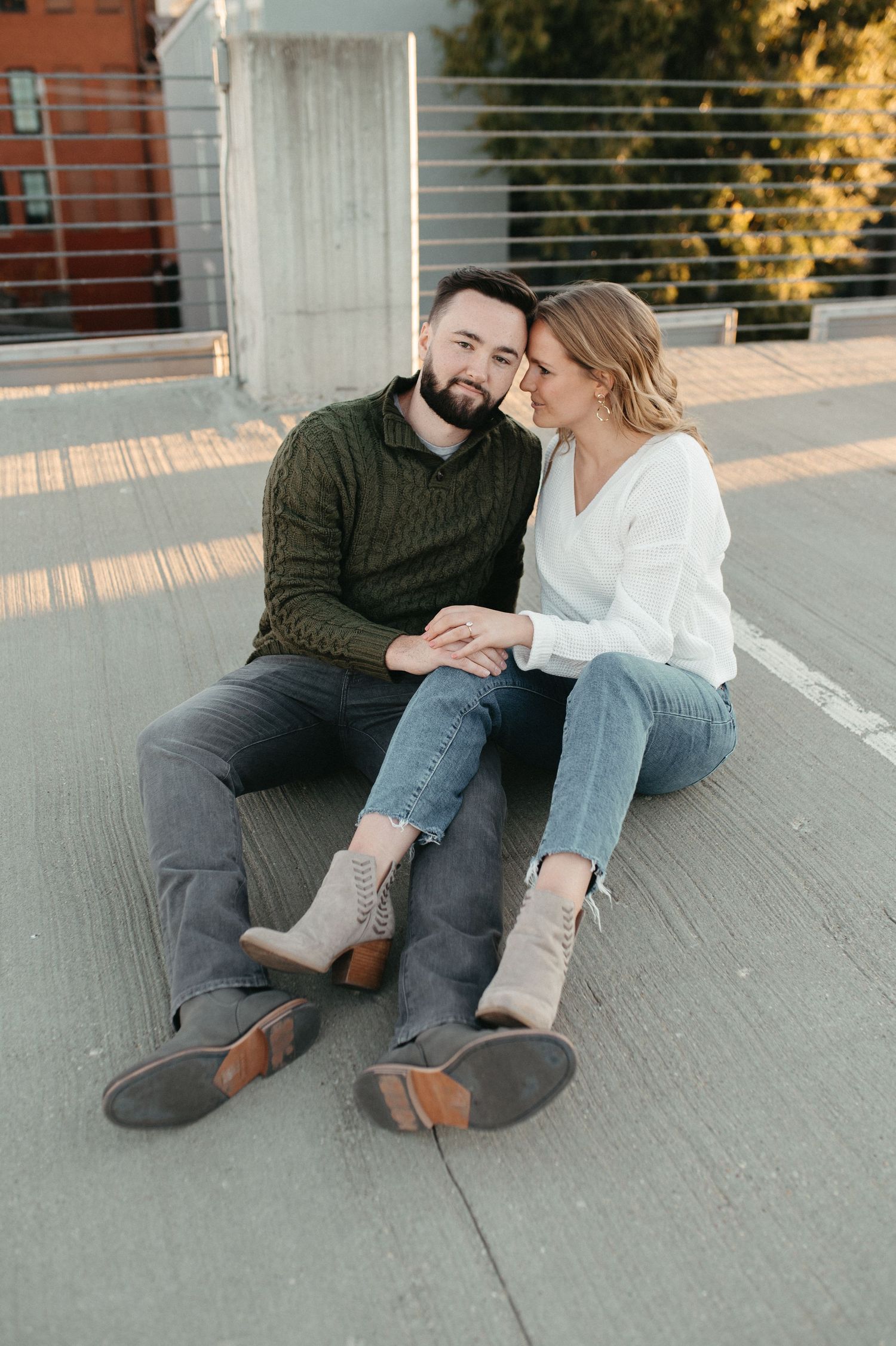 Couple relaxing together on concrete bench with sunset lighting.
