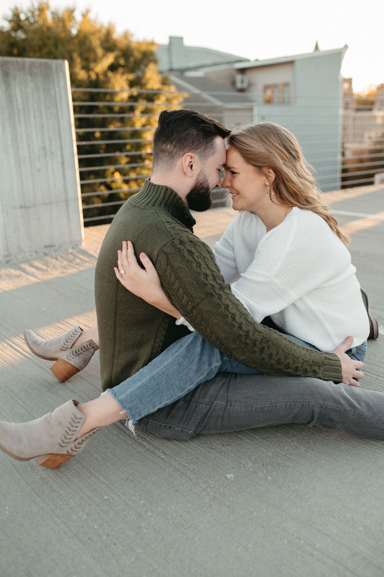 A tender embrace between a couple wearing cozy sweaters during their outdoor photoshoot.