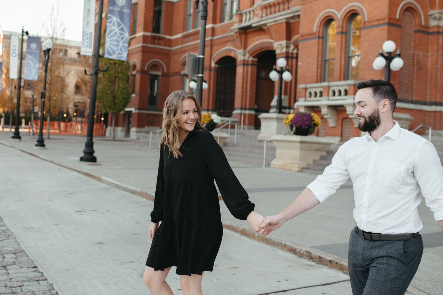A couple in coordinated black and white outfits dancing on a city street.