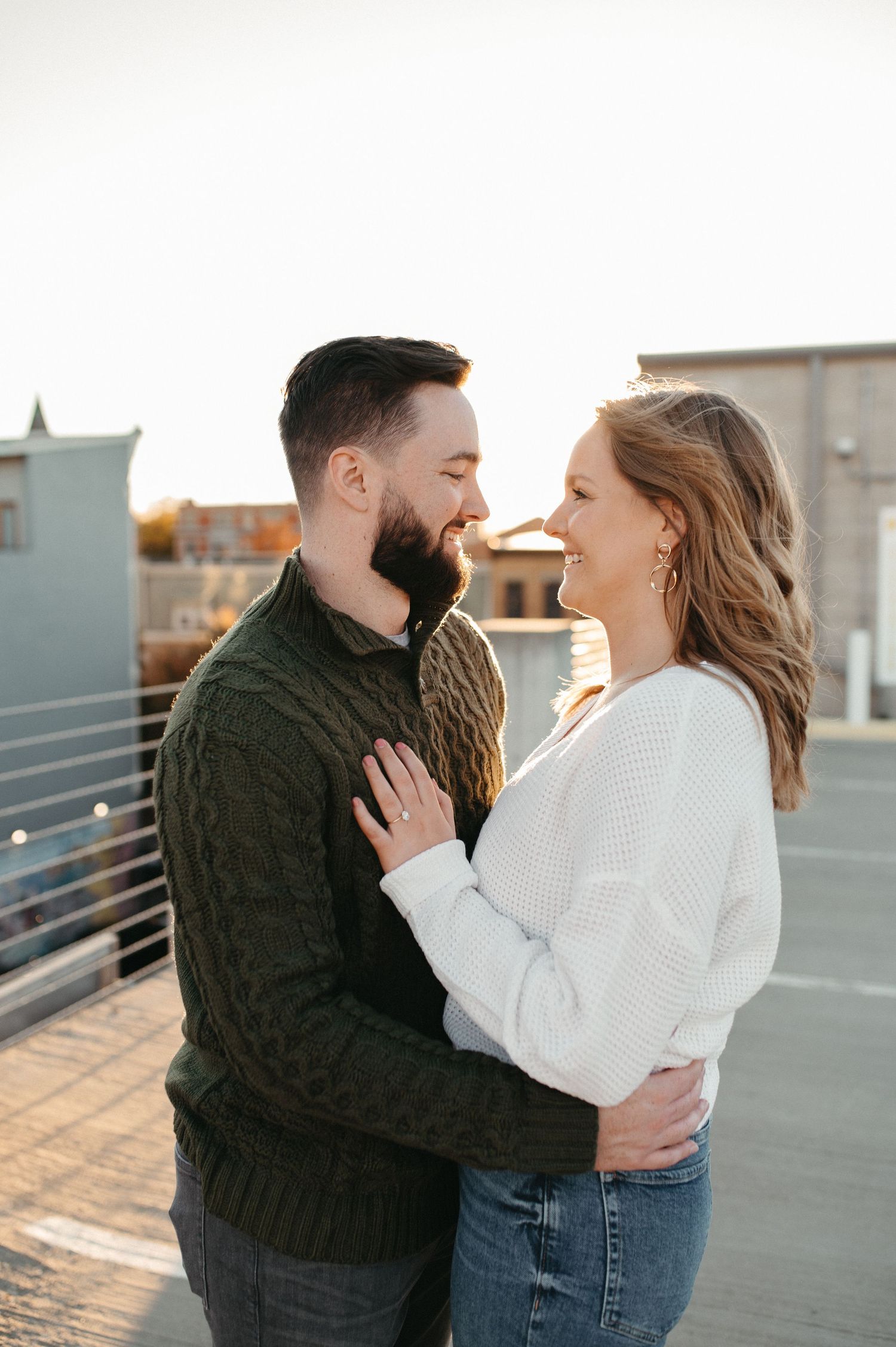 A romantic couple embracing on a rooftop during golden hour.