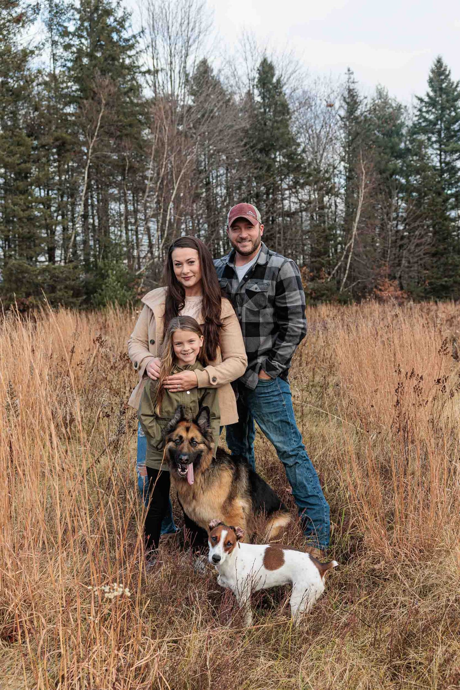 Family and dogs standing in field, family photography