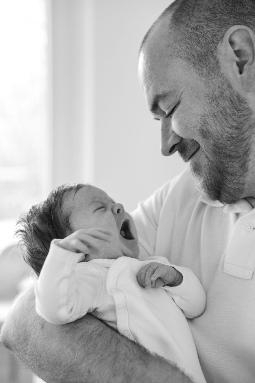 A father is holding a newborn baby.