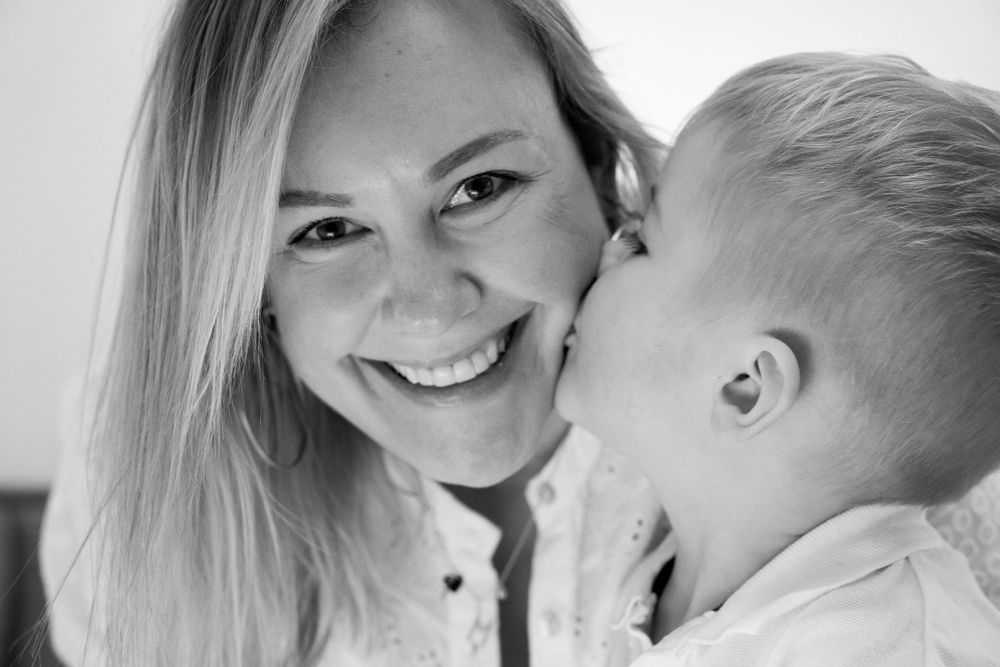 A mother is kissed by her little son.