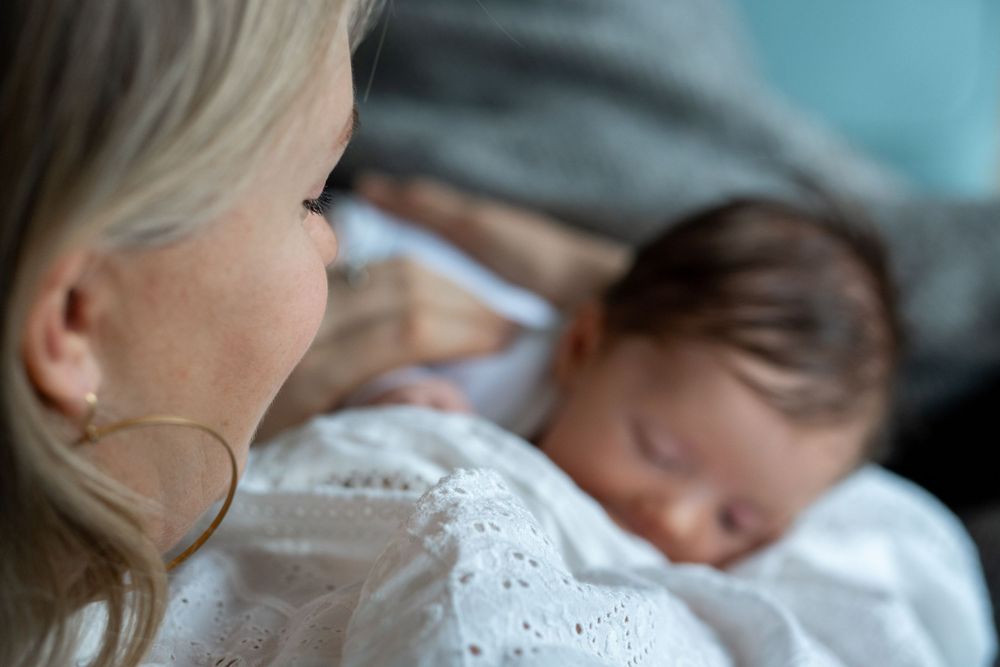 A woman is breastfeeding a newborn.