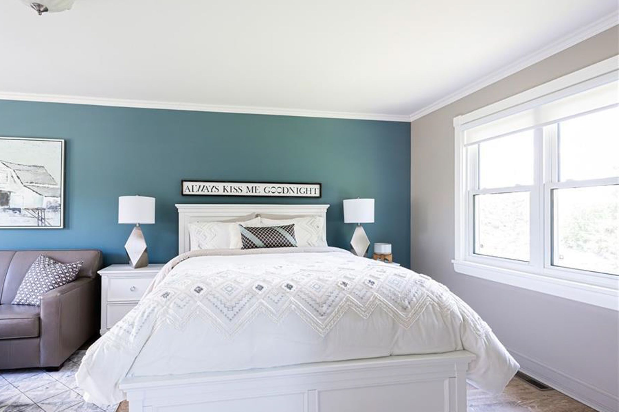 Serene bedroom with teal accent wall, white bedding, and matching table lamps.