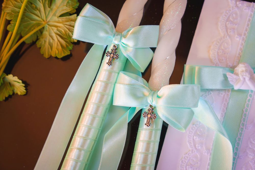 Mint green satin bows with crystal embellishments attached to white lace trim.
