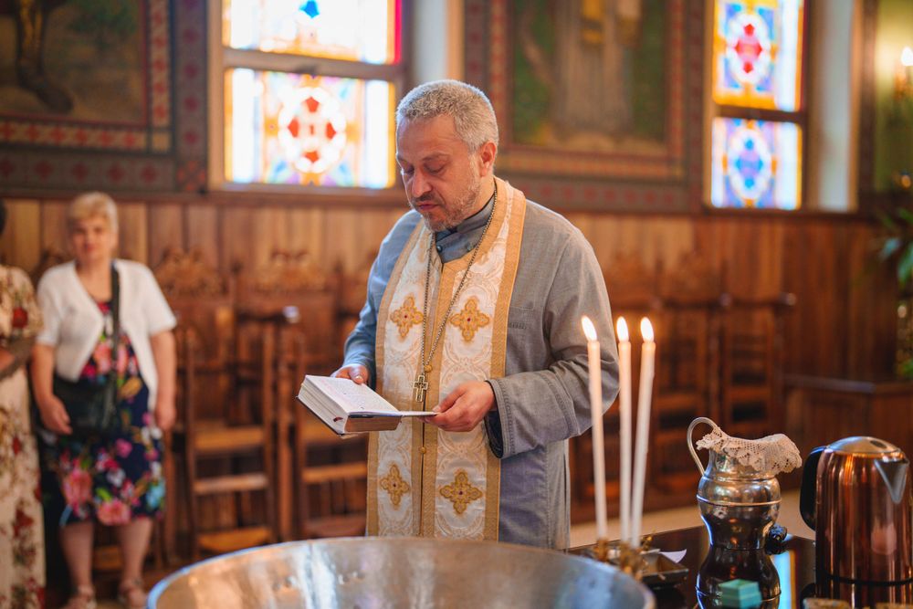 Priest conducting a religious ceremony in traditional vestments inside a church.