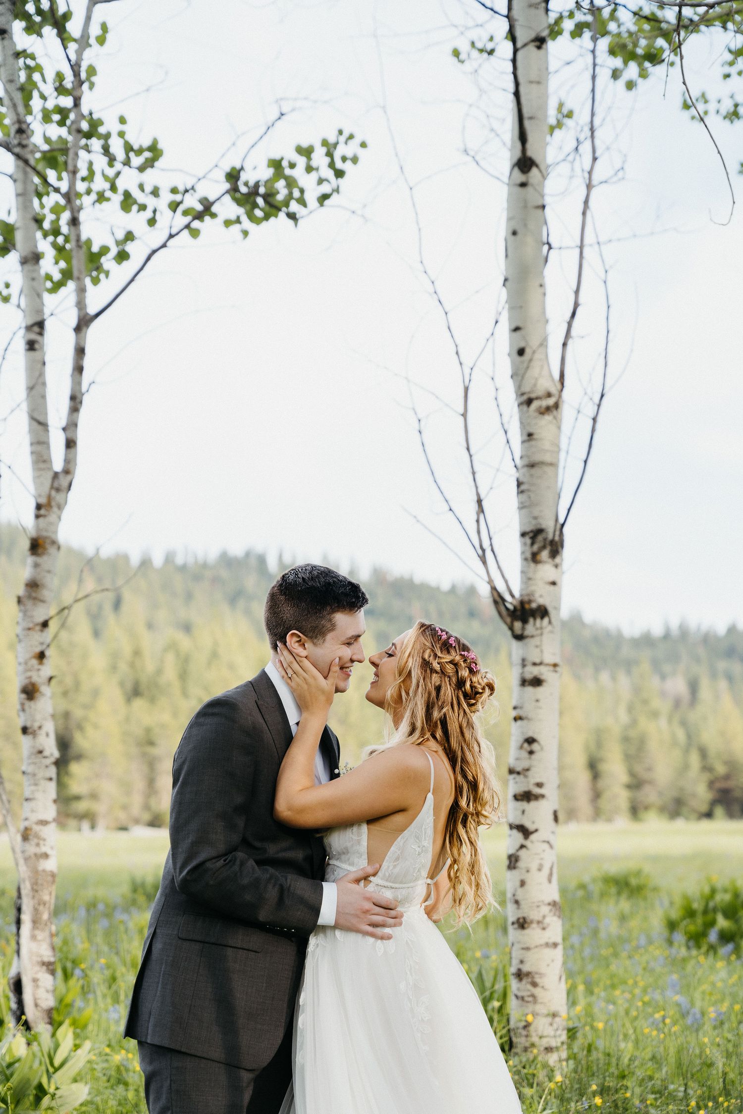 Romantic moment between newlyweds in white birch forest.