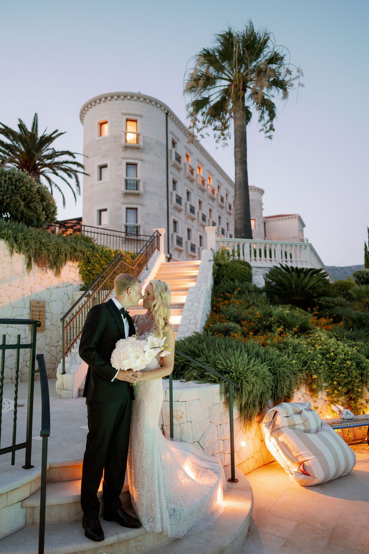 A romantic evening portrait at Korta Katarina hotel with illuminated steps and palm trees.