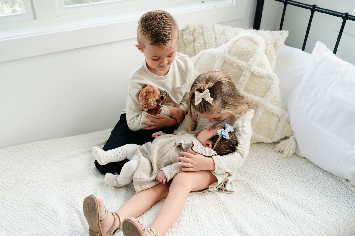 Children sitting on white couch looking at something together.