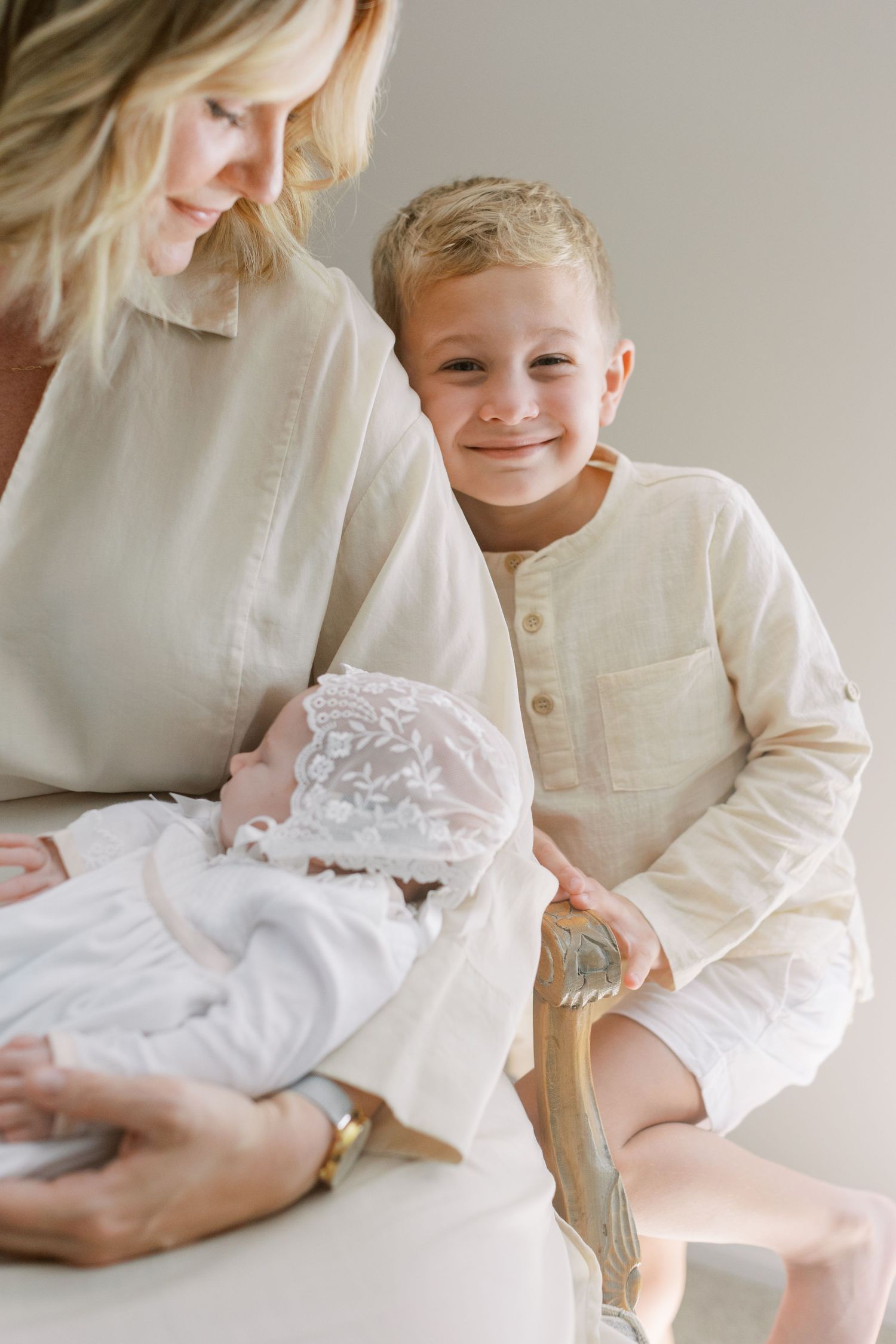 Intimate family portrait in white clothing sitting together.