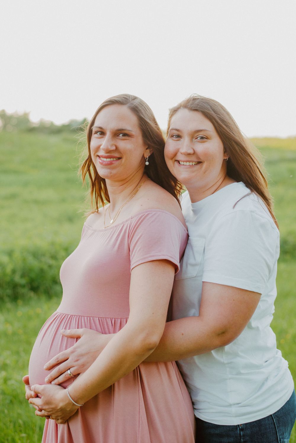Two moms smiling during maternity session in Valley Forge Park
