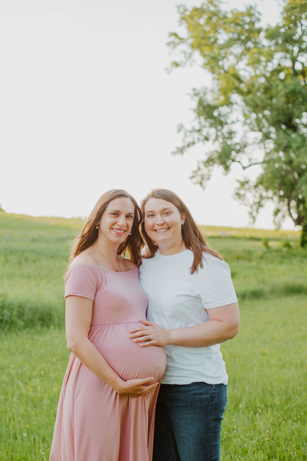 Two moms smiling during maternity session in Valley Forge Park