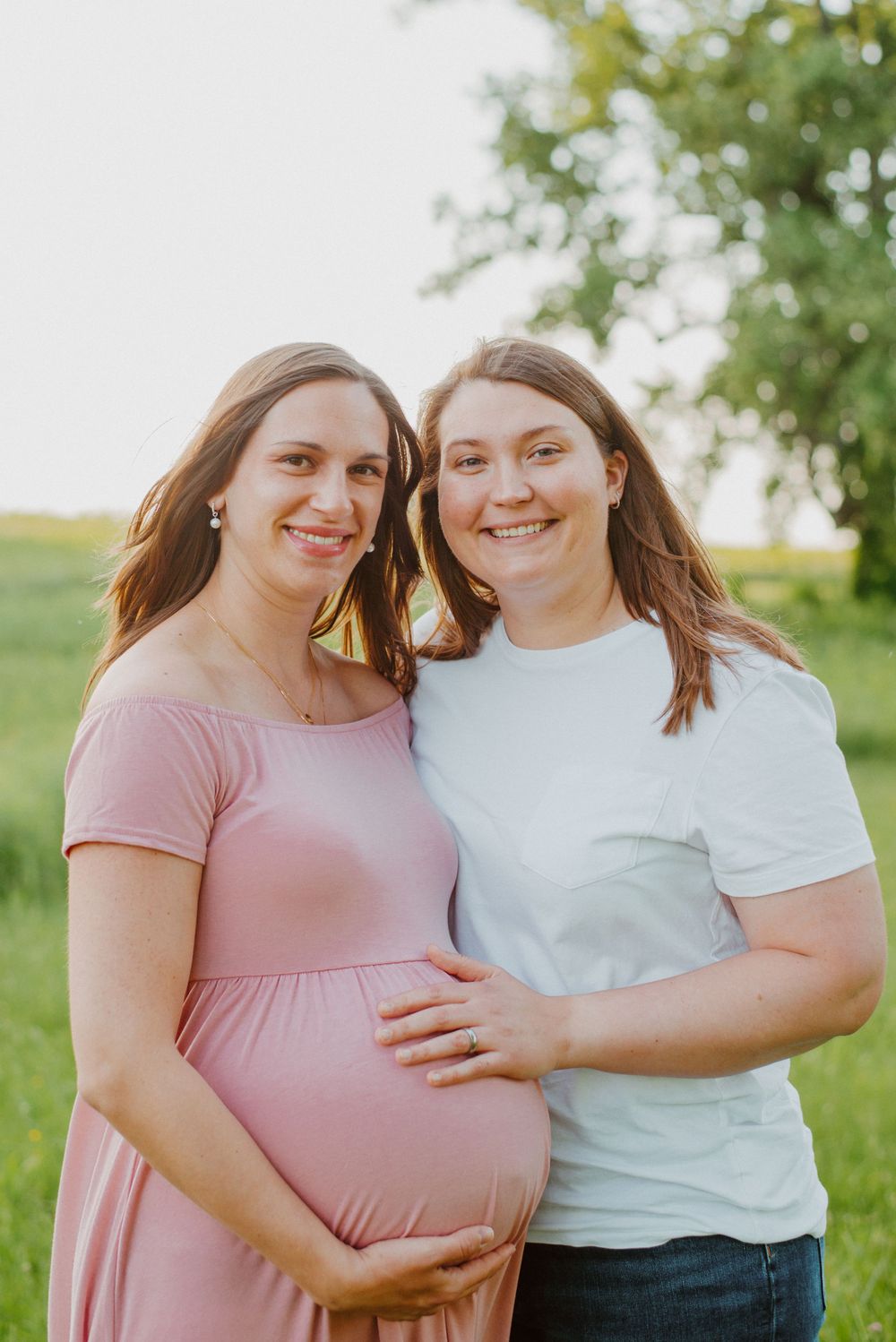 Two moms smiling during maternity session in Valley Forge Park