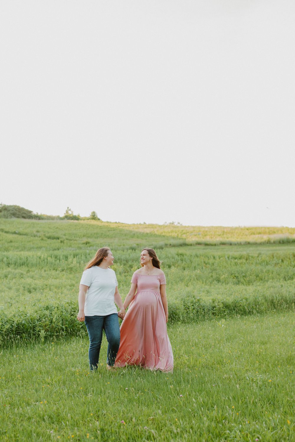 Same-sex couple walking pose during maternity session in Valley Forge Park