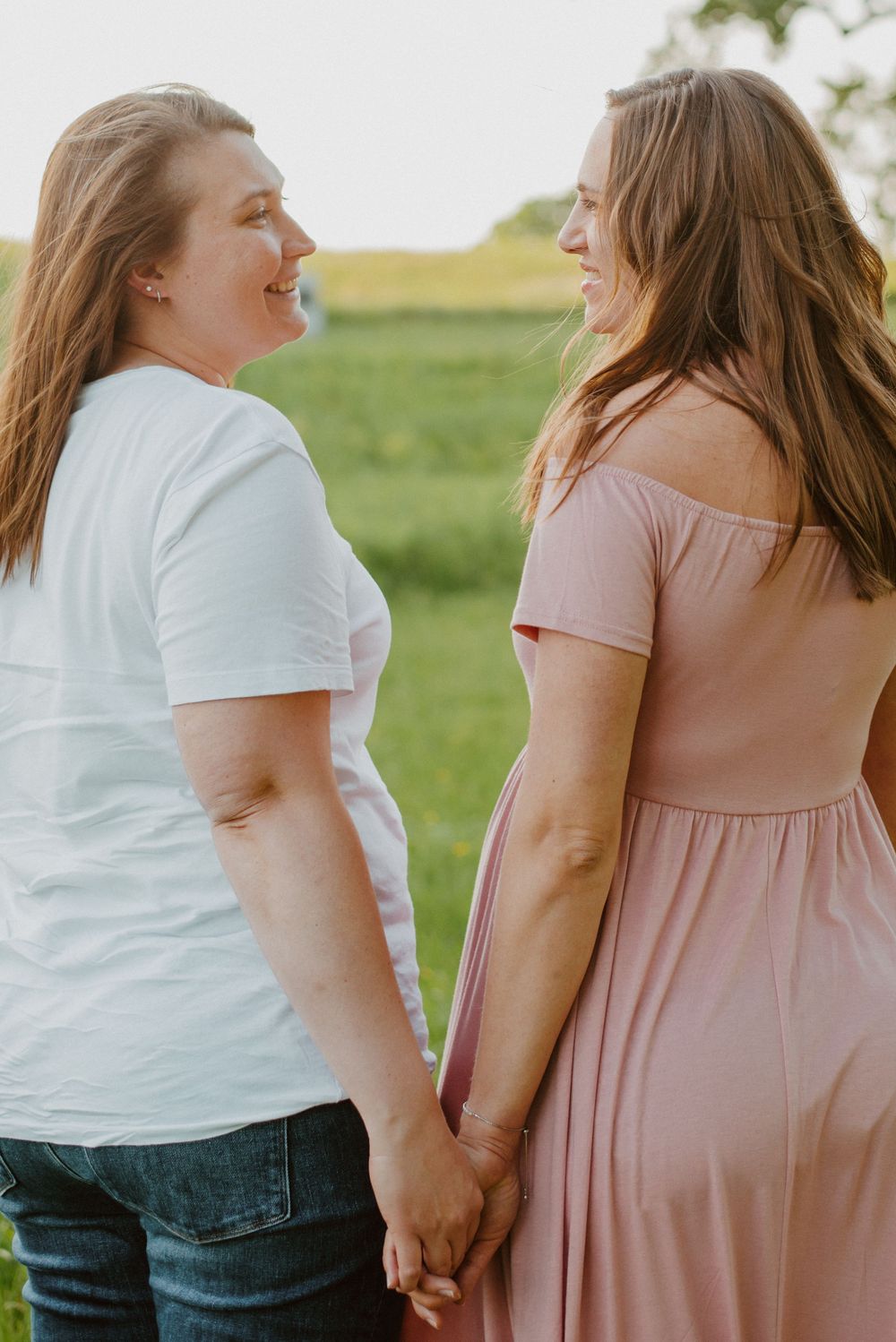 Two moms holding hands during maternity session in Valley Forge Park