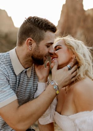 Intimate desert engagement photo with dramatic rock formations.