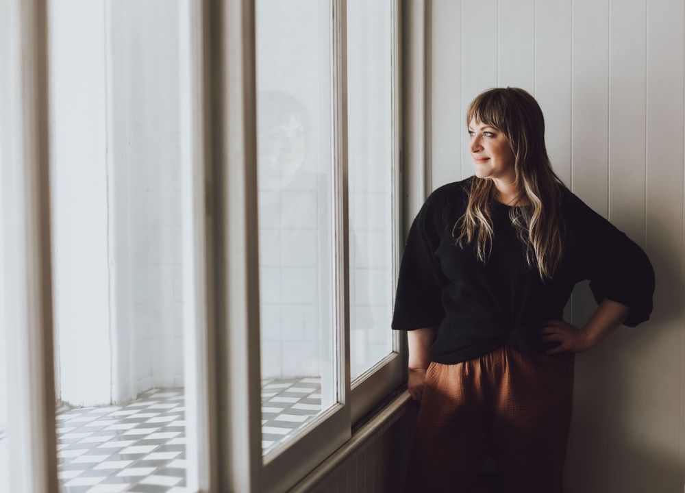 Portrait session against white wall with natural window light.