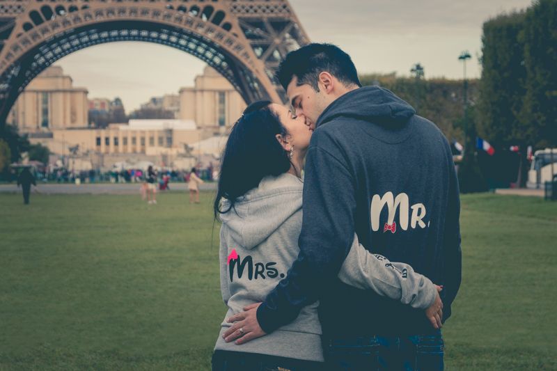 Newlyweds enjoying a romantic moment together, posing in front of the Eiffel Tower