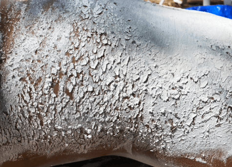 Detailed macro shot of textured metallic surface with crackled paint effect.