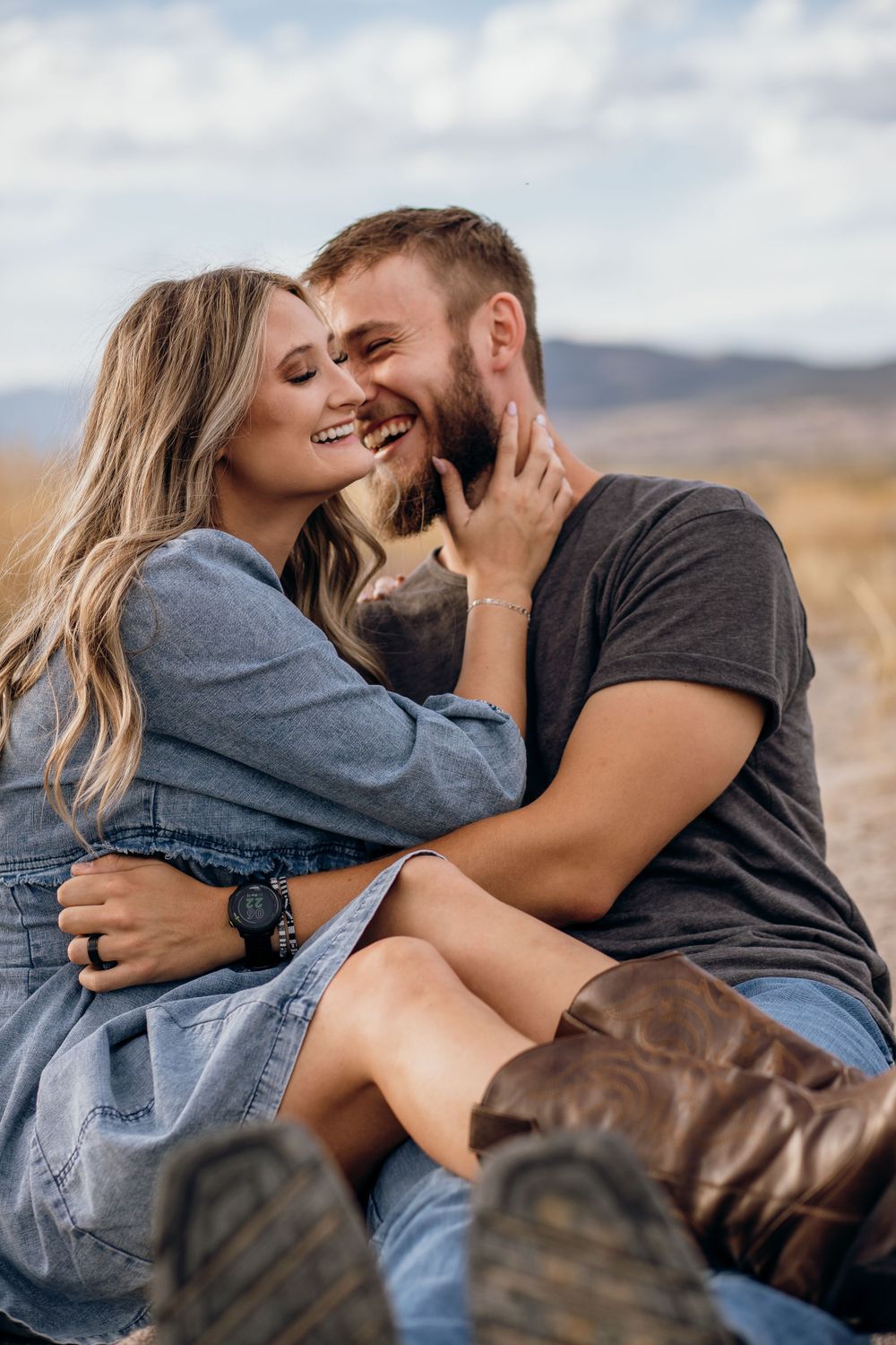A romantic embrace captured in golden light with mountains in the background.