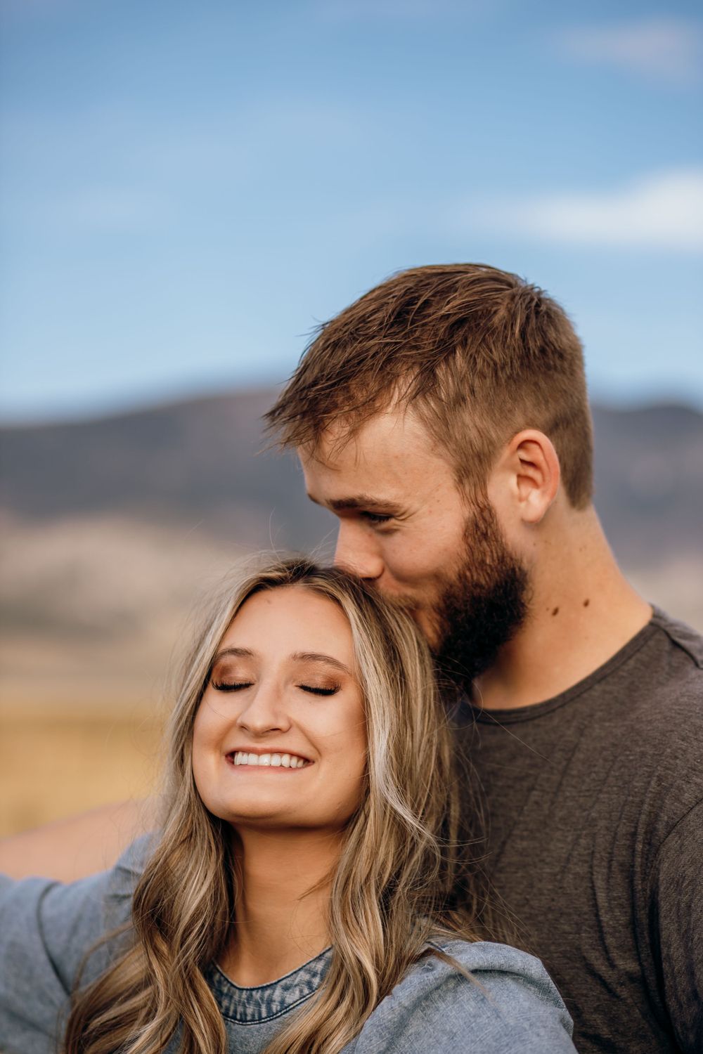 A tender moment captured against a mountainous desert landscape.