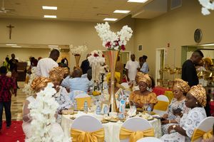 Elegant banquet hall decorated with tall floral centerpieces and gold accented table settings.