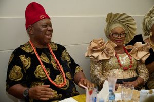 Guests in traditional Nigerian attire enjoying a formal celebration.