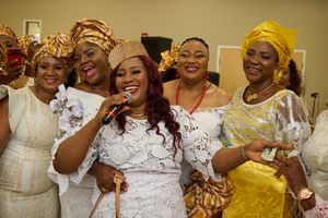 A group wearing traditional African attire pose together at a celebration.