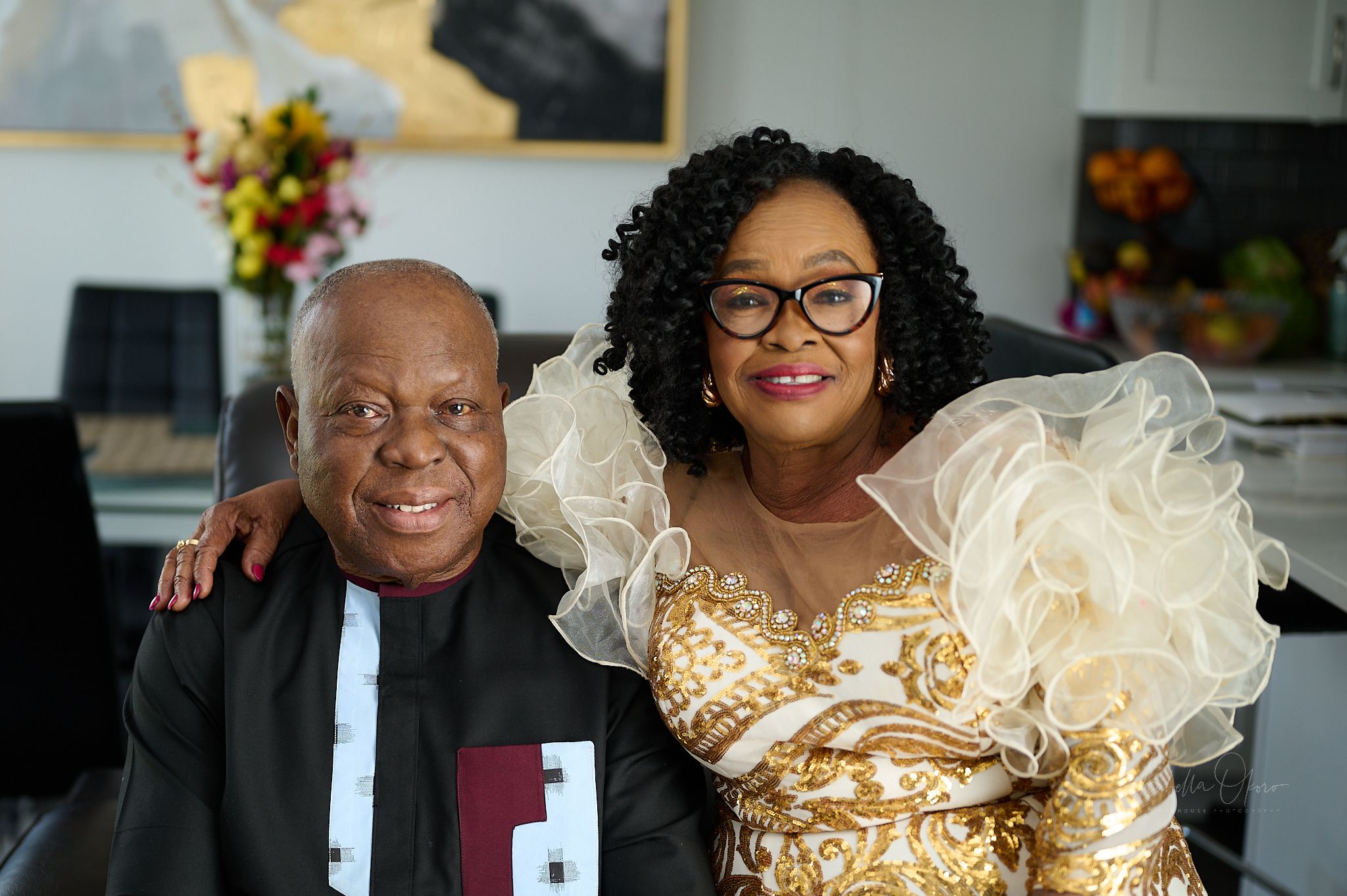 Family portrait featuring traditional African formal wear at celebration event.