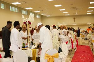 Guests gathered at decorated tables during a celebratory event in a banquet hall.