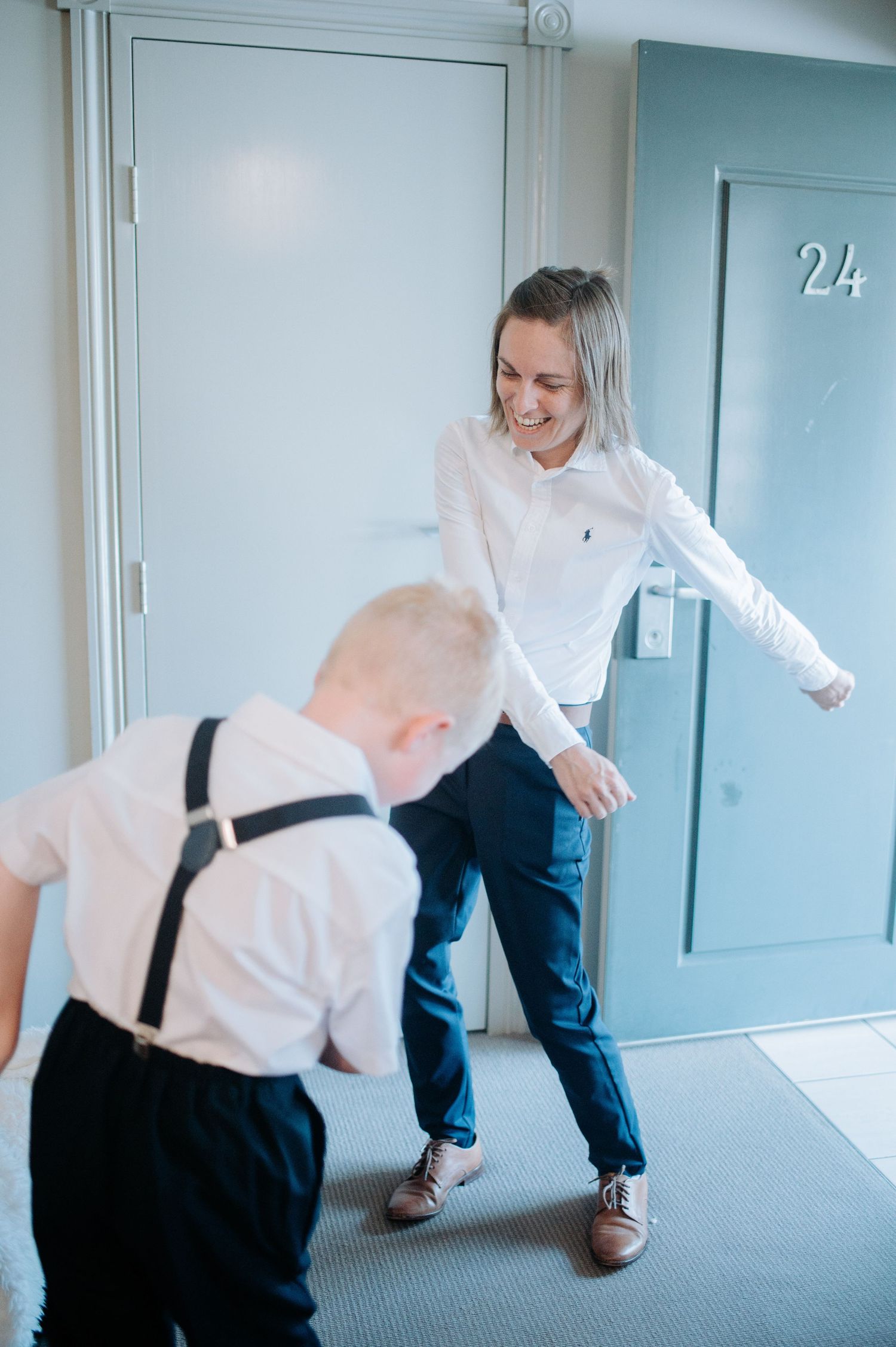A playful moment between two people in a hallway marked with number 24.