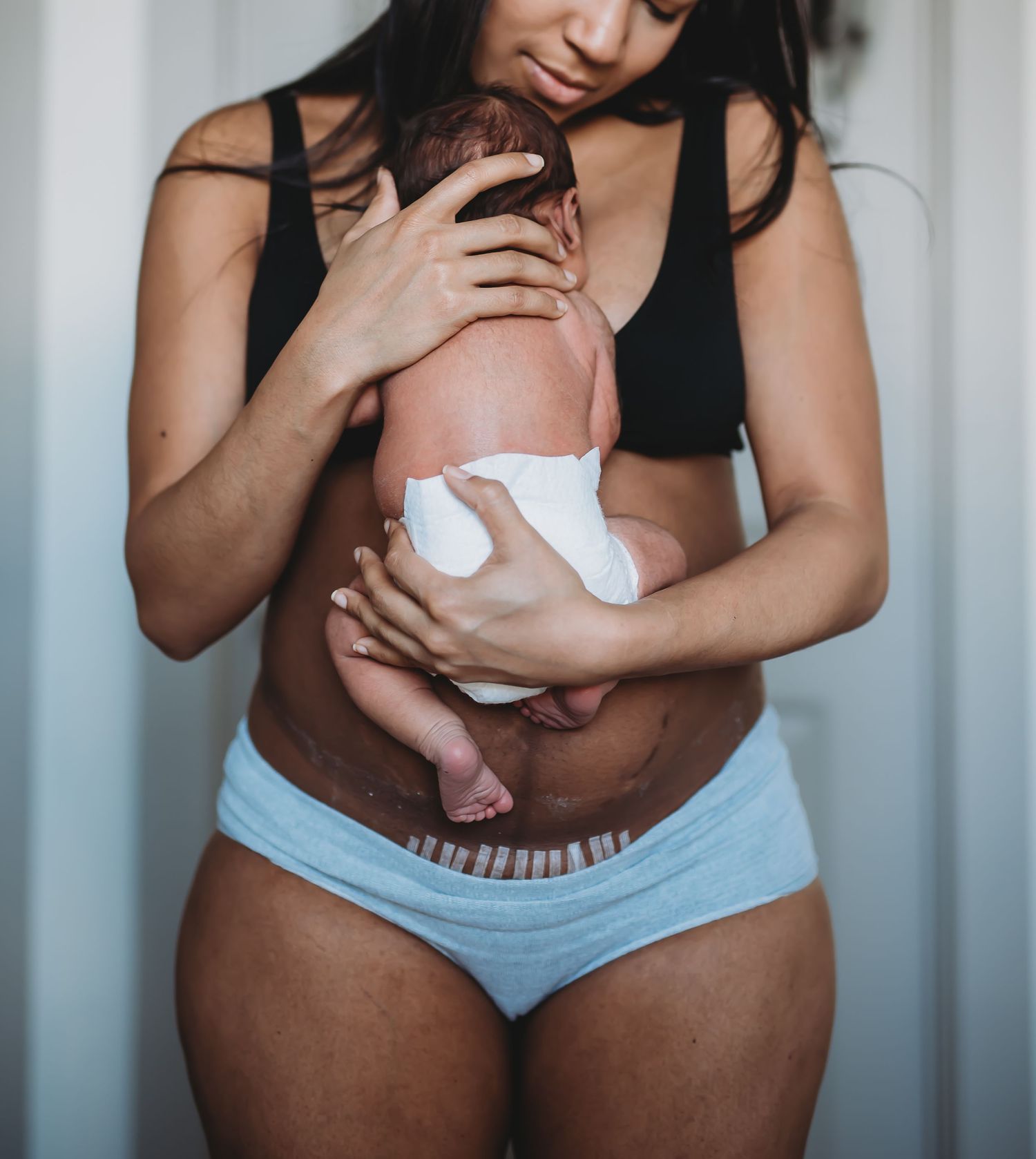 mom holding baby against chest. mom and baby skin to skin time. mom and baby after delivery. dallas birth photographer