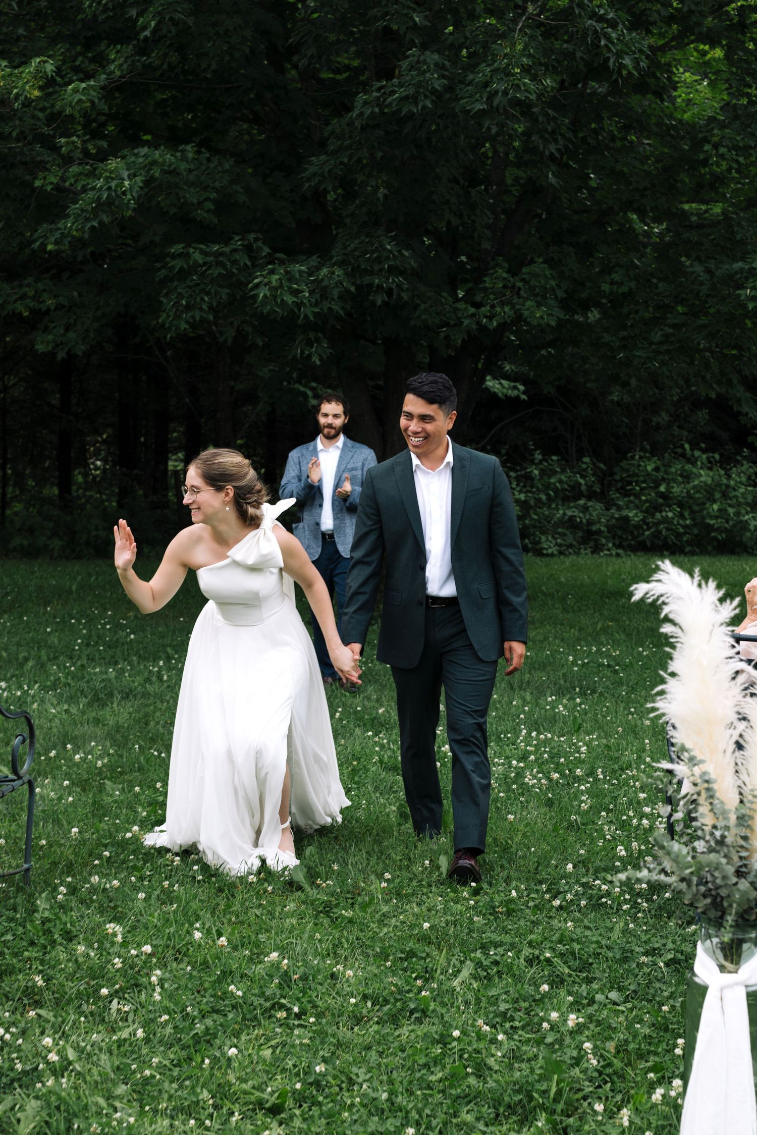 A joyful wedding celebration in a garden with decorative white pampas grass.