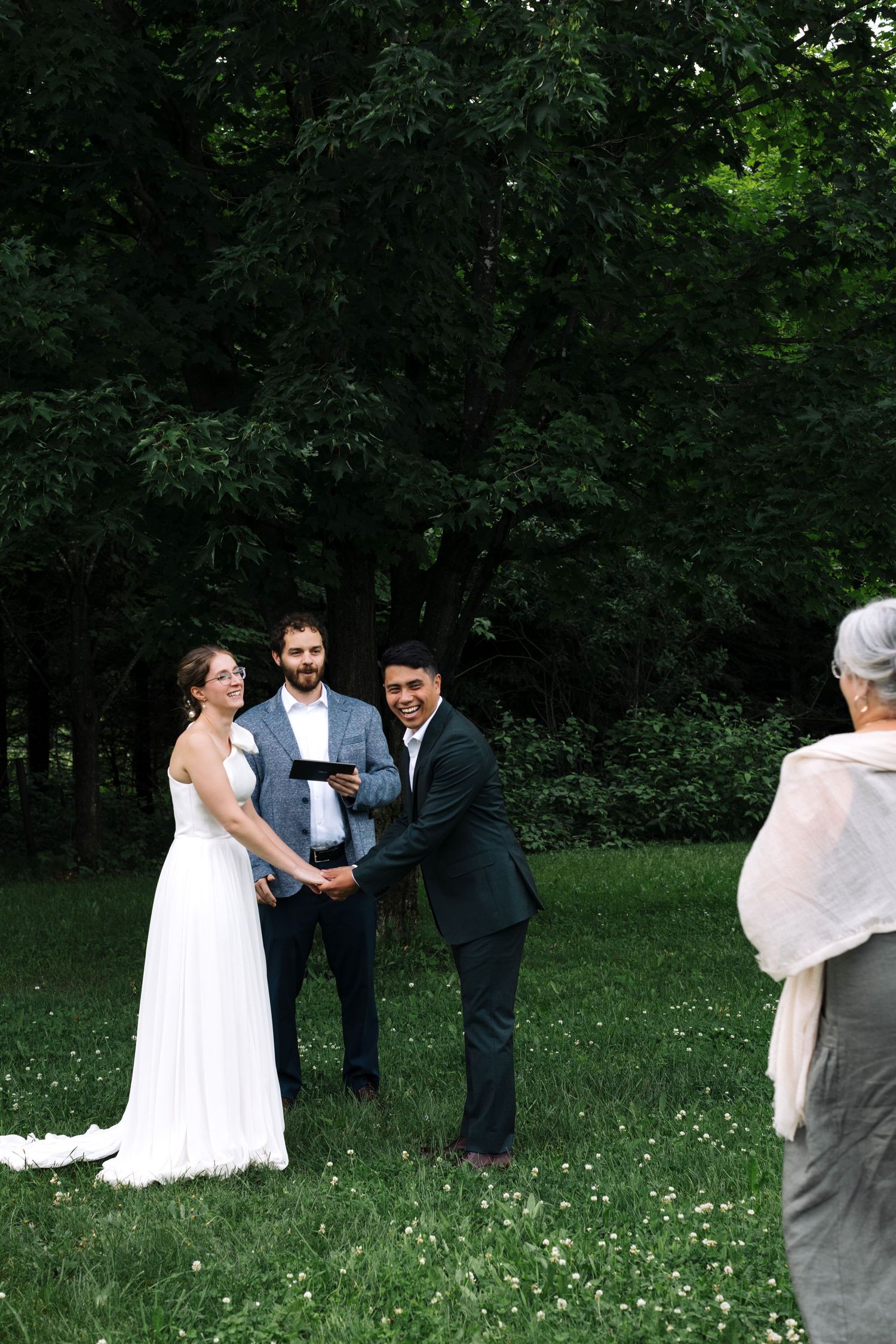 Outdoor wedding ceremony in a lush green garden setting.
