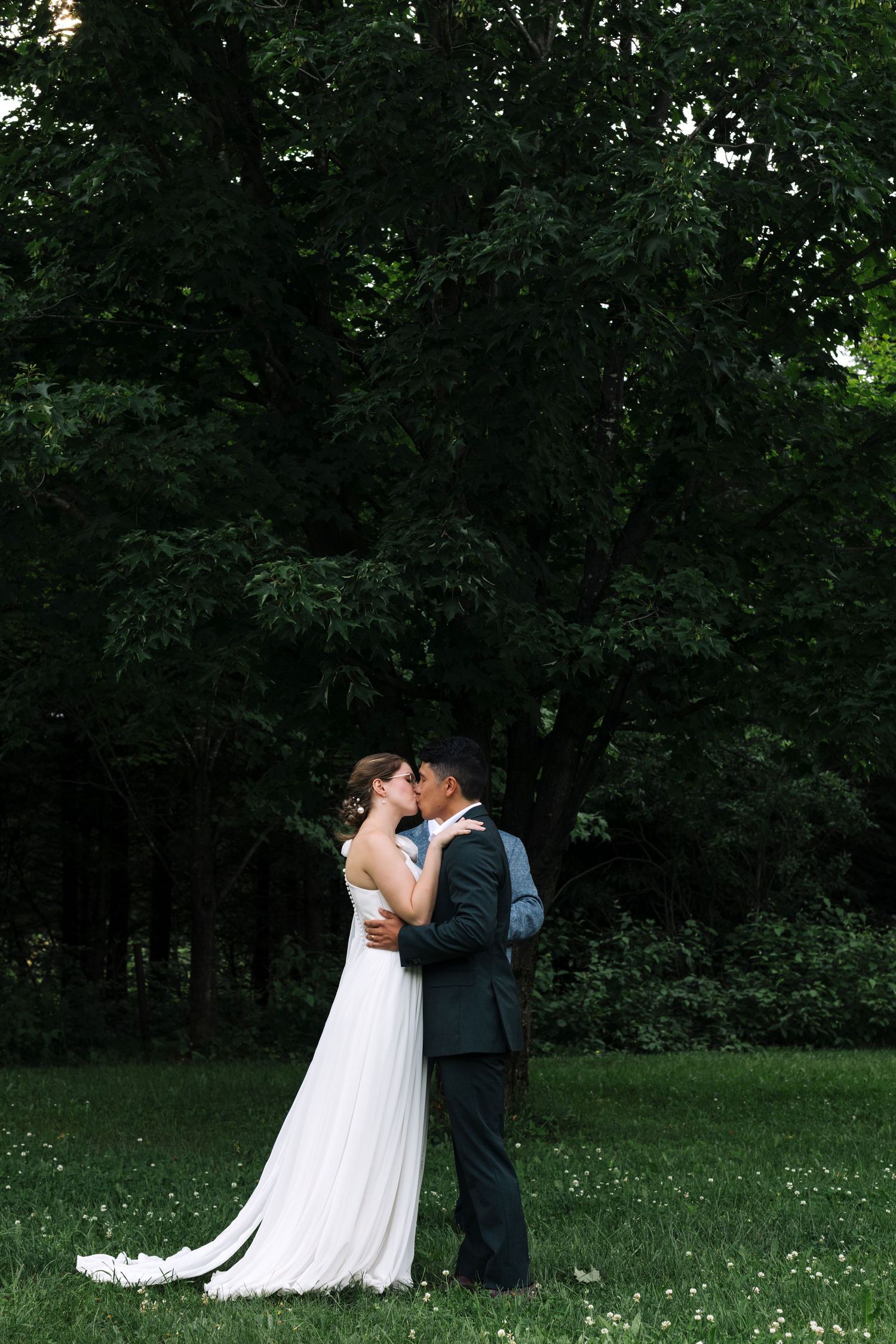 A romantic wedding moment captured in a serene garden setting with blooming wildflowers.