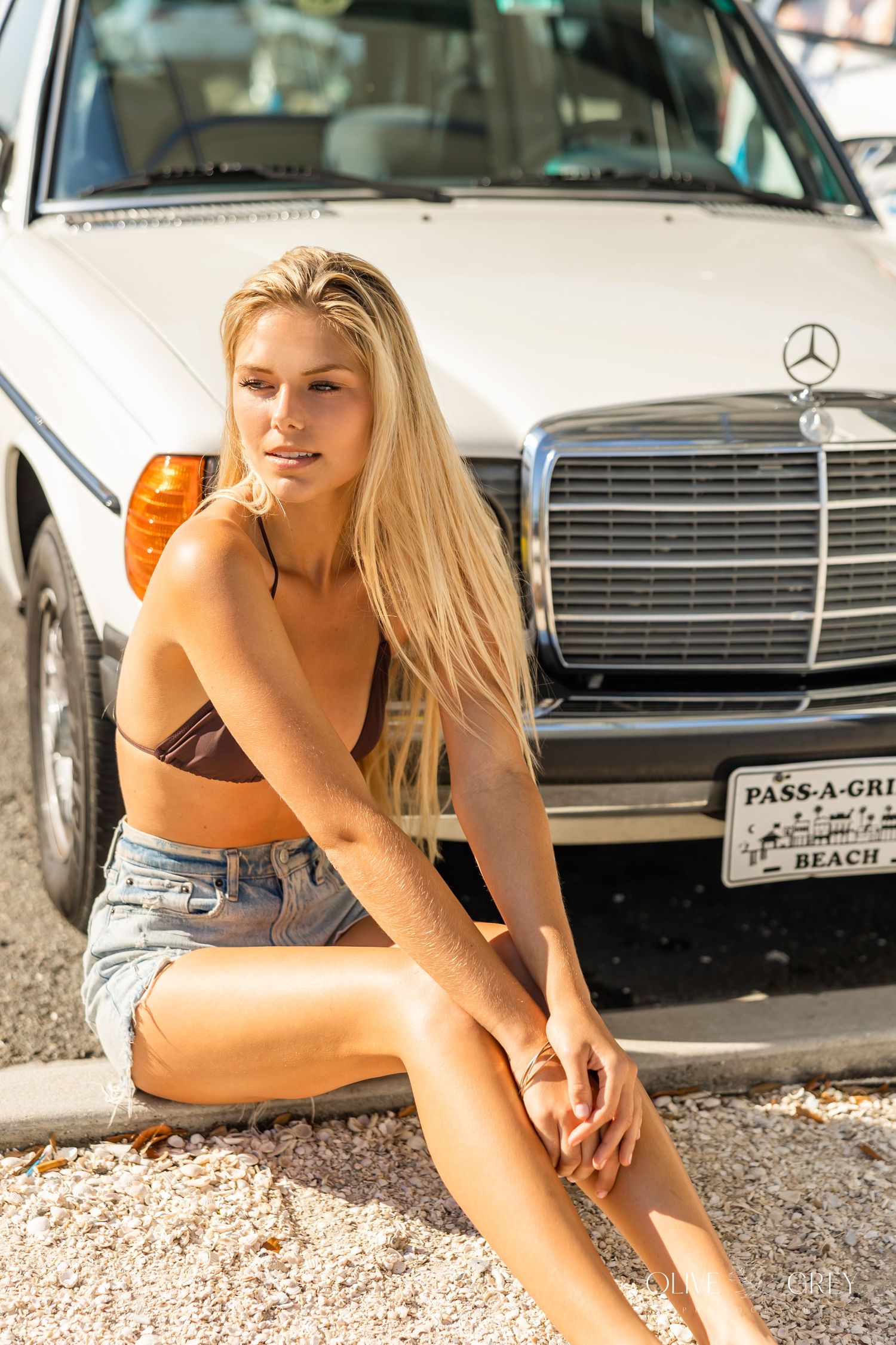 A white Mercedes-Benz sedan parked with a vintage Pass-A-Grille Beach license plate visible.