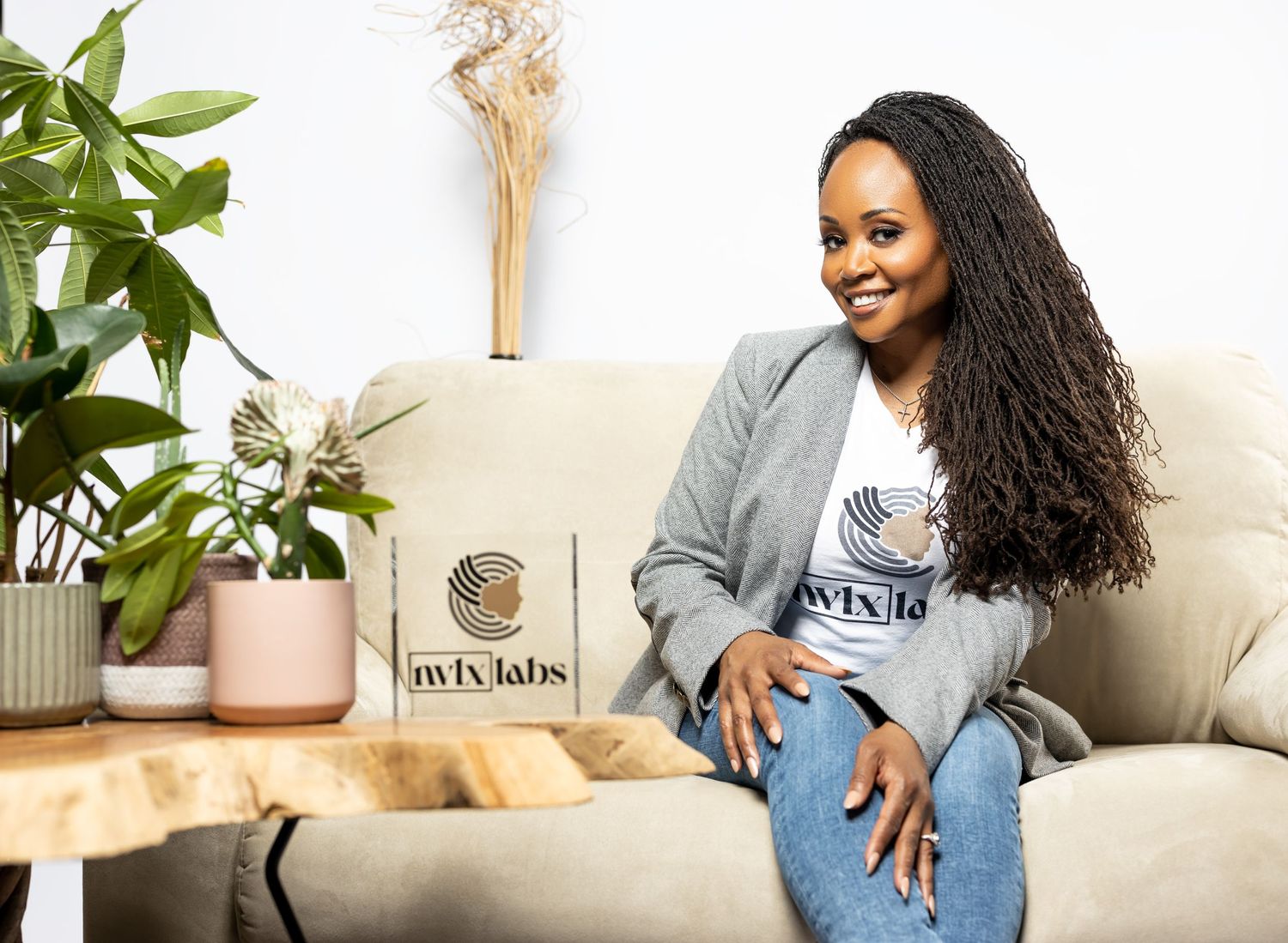 Lifestyle photo of woman in casual attire relaxing on cream colored sofa.