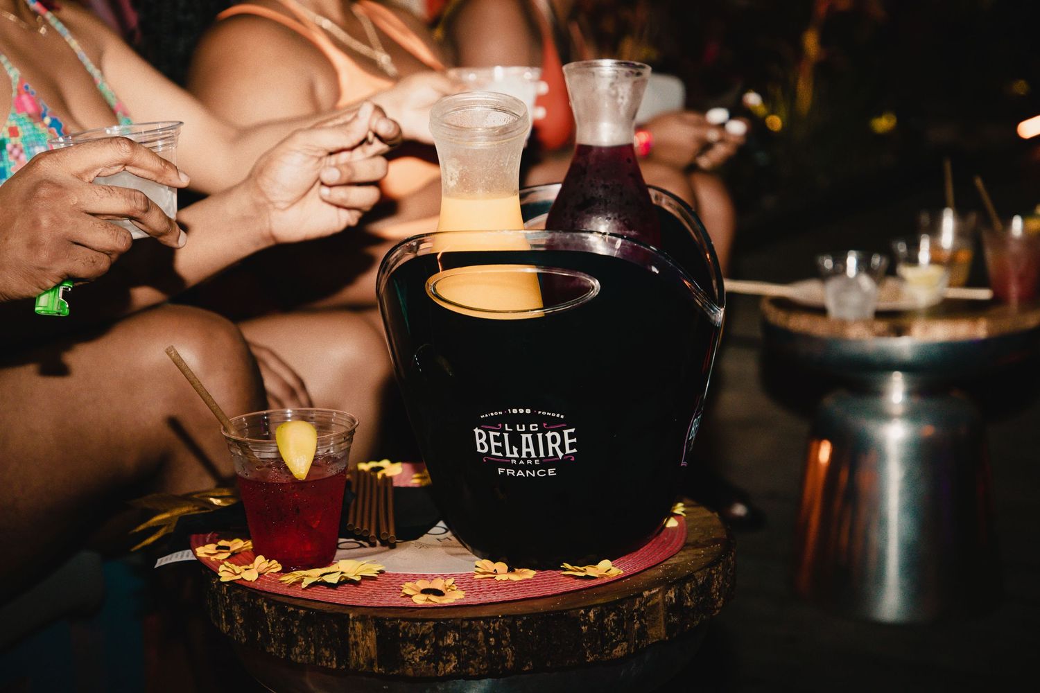 Close up of drinks being served on wooden surface with dark background.