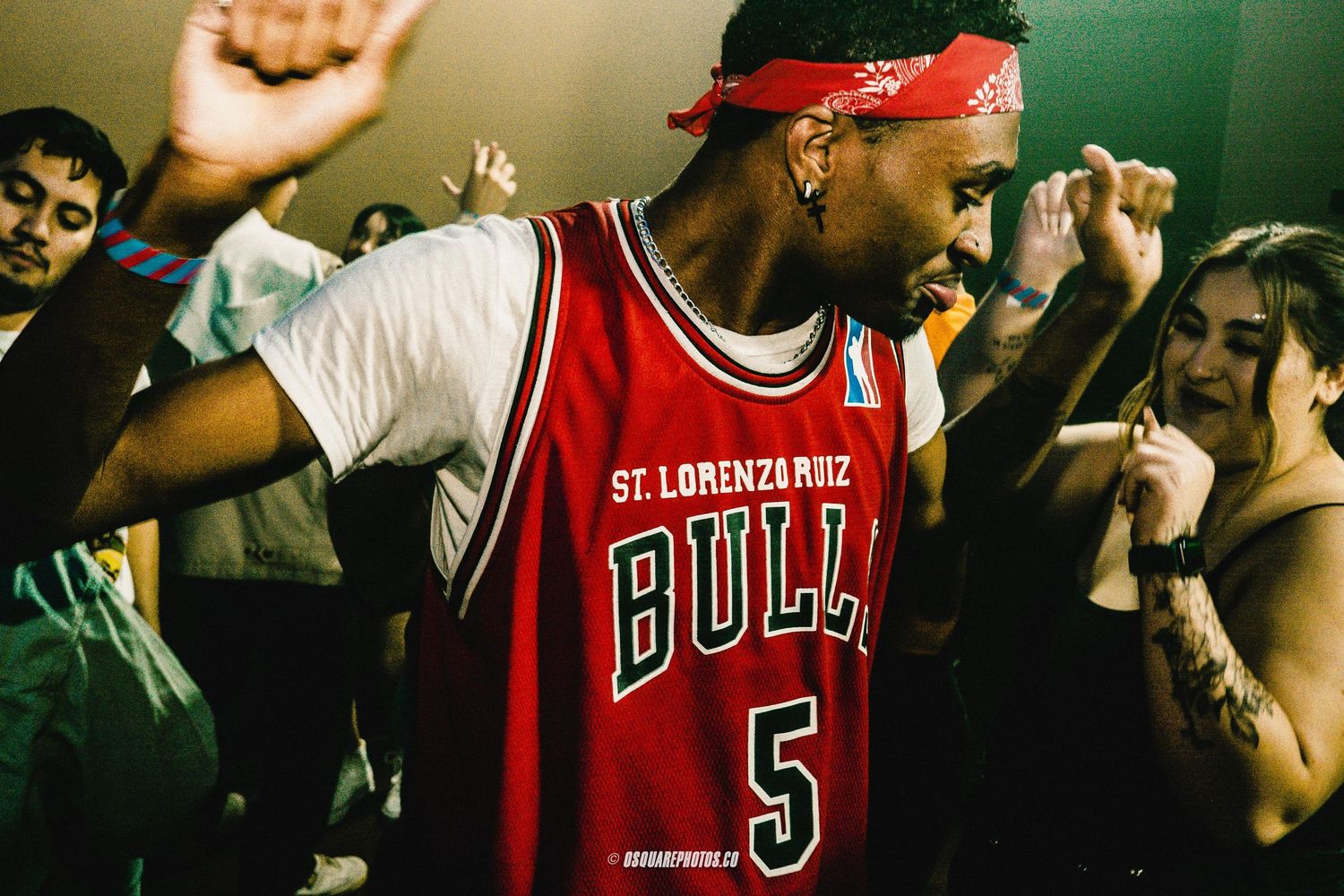 Energetic performer in a Bulls jersey dancing at a lively nightclub event.