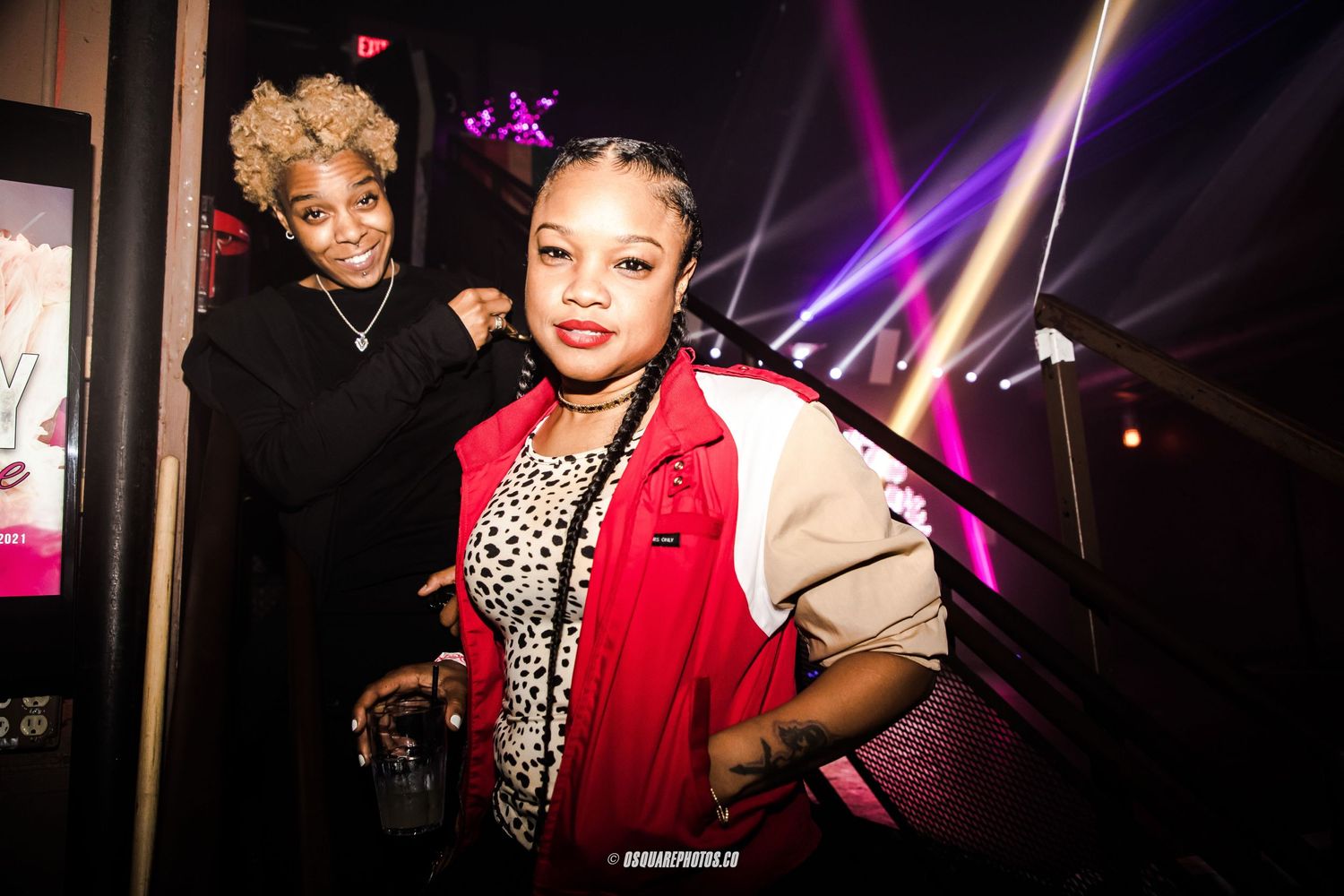 Performers posing backstage with dramatic purple lighting effects.