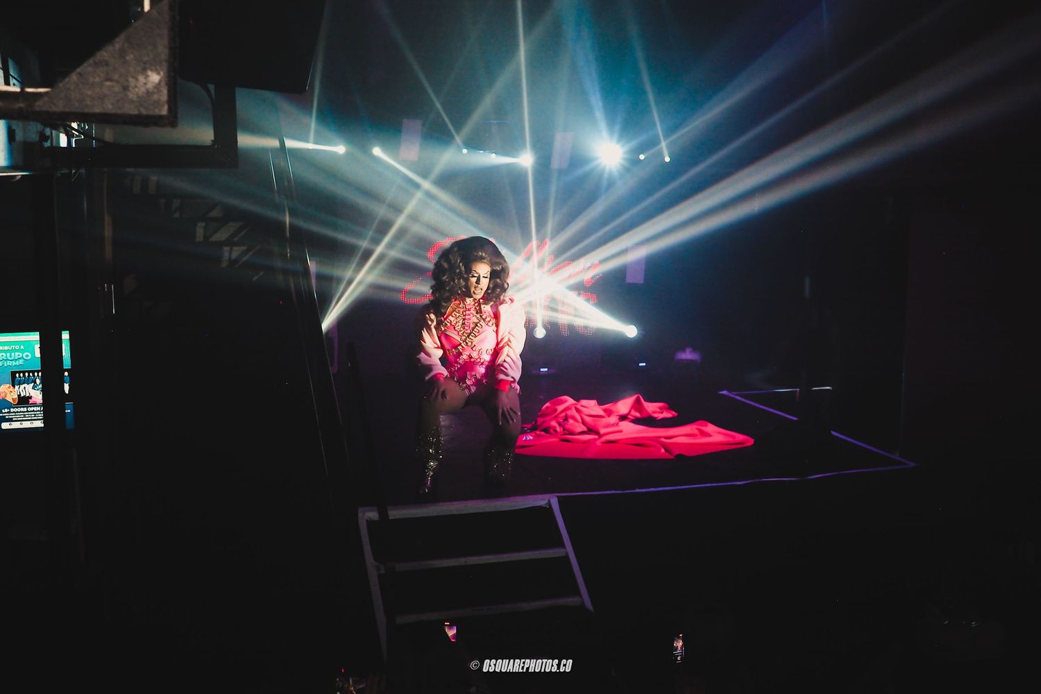 DJ performing on stage with dramatic lighting and smoke effects.