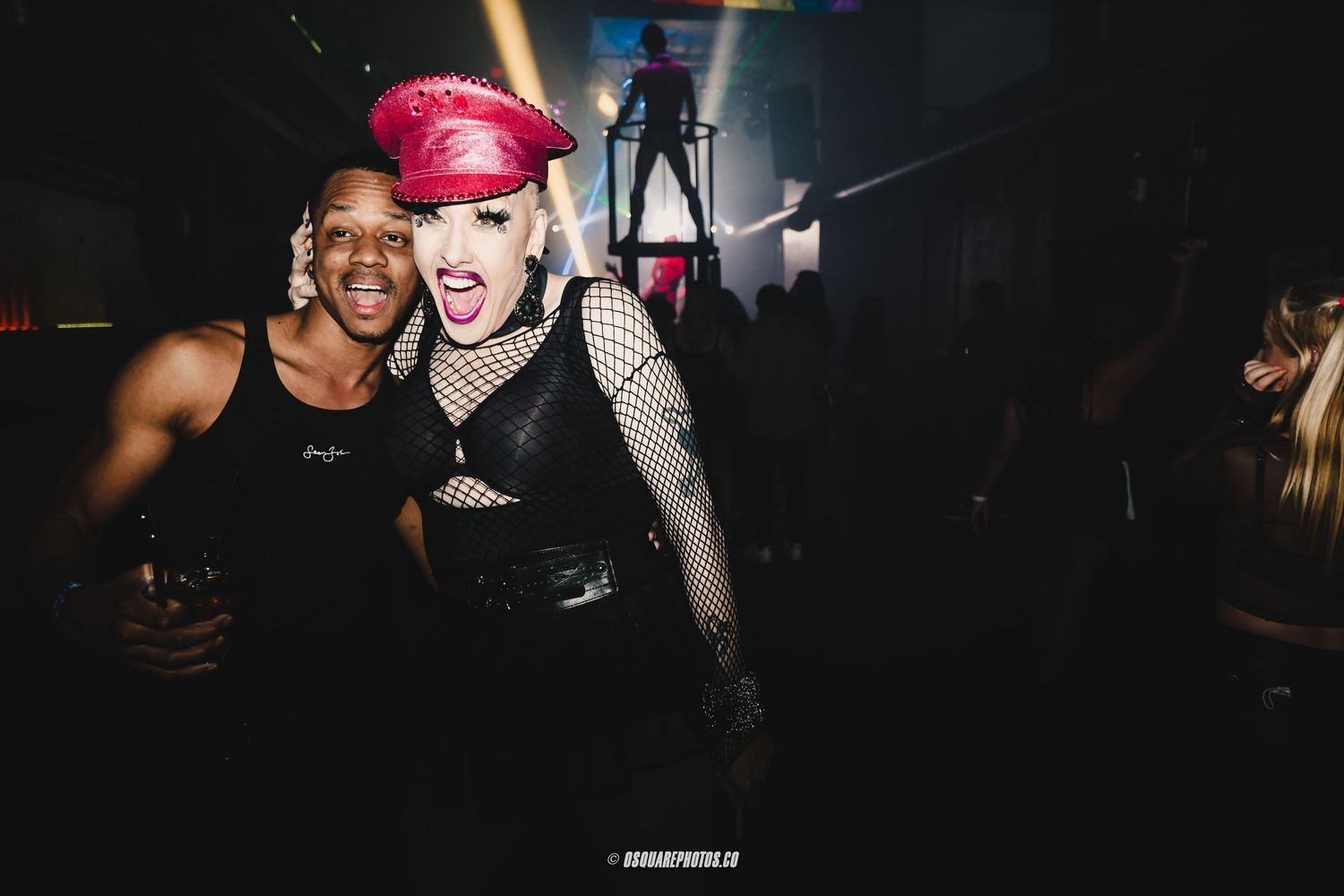 Energetic nightclub scene with people dancing under dark atmospheric lighting.